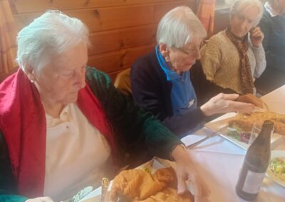 Drei ältere Menschen an einem Tisch in einem holzvertäfelten Gastraum, auf Tellern große panierte Schnitzel; an der Wand ein Schild: 'Keine Kartenzahlung möglich! Cash only!'